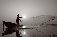 Fisherman Of Bangpra Lake In Action When Fishing.(Sepia Style)