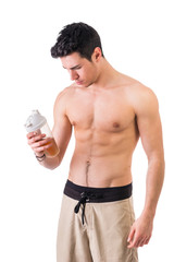 Wall Mural - Attractive young man holding protein shake bottle