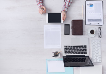 Wall Mural - Businessman working at desk with a digital tablet