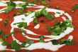Detail of tomato soup with yogurt and parsley.