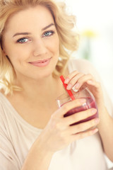 Poster - Young woman with drink the kitchen