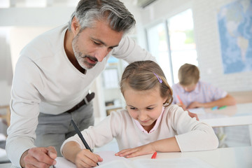 Teacher with schoolgirl in class