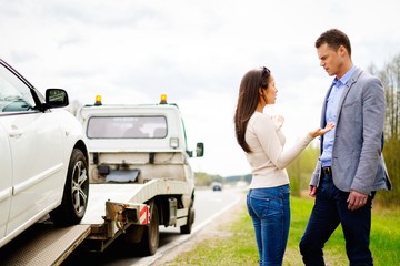 Wall Mural - Couple near tow-truck picking up broken car