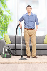 Canvas Print - Young man posing with a vacuum cleaner