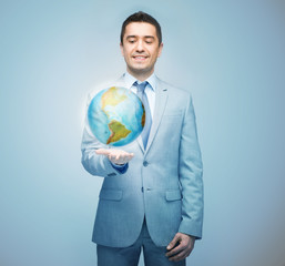 happy businessman in suit showing globe hologram
