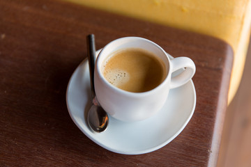 Wall Mural - cup of black coffee with spoon and saucer on table