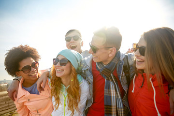 Wall Mural - smiling friends in sunglasses laughing on street