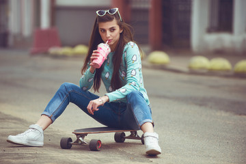 Beautiful young woman posing with a skateboard seat on skate