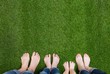 © Artsem Martysiuk - Family legs standing on green grass