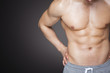© cristovao31 - Image of a fit man showing six pack abs against grey background