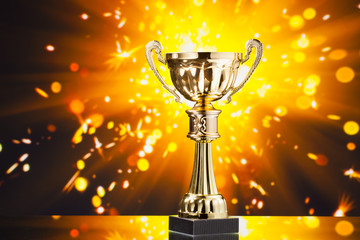 Wall Mural - gold cup trophy against shiny sparks background