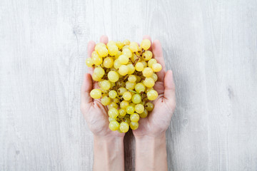 Hand with freshly grapes on a wooden table