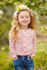 portrait of little girl outdoors in a lush garden.