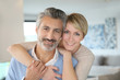 © goodluz - Smiling middle-aged couple standing in brand new home