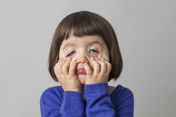 4-year old child playing with her face and eyes for fun