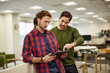 © Mint Images - Two men looking at a digital tablet screen.