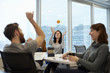 © Mint Images - Three business people, two women and a man, reaching up to catch a ball.