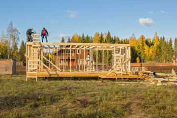 builders install a wooden frame of a house