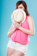 © Voyagerix - Cute girl holds summer straw hat covering her face