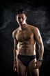 © theartofphoto - Handsome, fit young man wearing only underwear standing on black