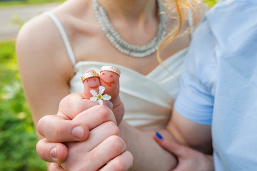 bride and groom are holding wedding rings