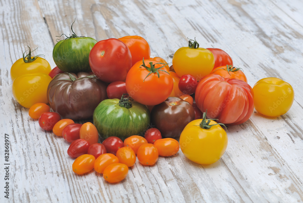 tomates de couleurs et de formes différentes sur fond bois blanc Stock — free download