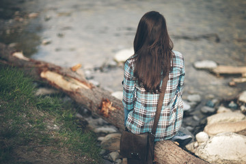 Young woman sitting along the river