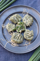 Canvas Print - Gnocchi with spinach and grated cheese on a tin plate.