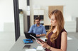 © contrastwerkstatt - frau im büro liest am tablet-pc