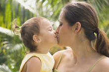 Hispanic Mother Kissing Baby