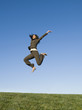 © Erik Isakson/Blend Images - Mixed race businesswoman jumping in field