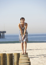 Asian Woman Standing On Posts At Beach