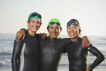 Multi-ethnic Women Wearing Wetsuits And Goggles