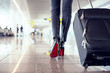 Woman walking in airport with hand luggage suitcase