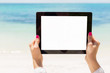 Woman holding tablet computer with empty screen on the beach