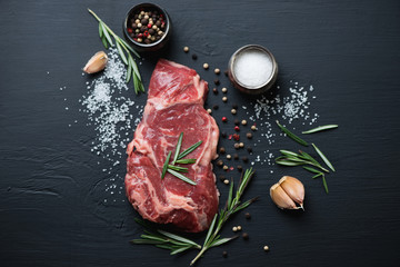 Wall Mural - Raw ribeye steak with various herbs and spices, above view