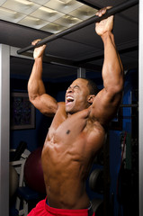 Wall Mural - Yelling body builder doing pull up