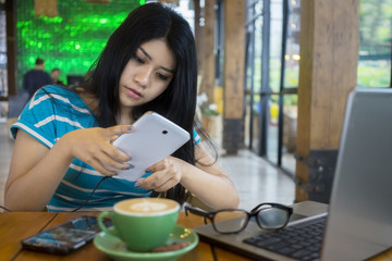 Canvas Print - Pretty woman texting in the cafeteria