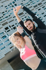 Wall Mural - Young couple doing stretching outdoors