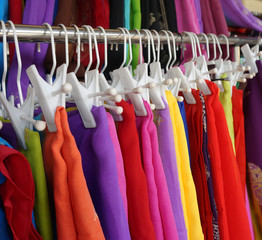 Row of colourful clothes hanging on iron railing