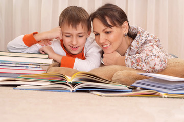 Canvas Print - mother reading a book to kid boy 