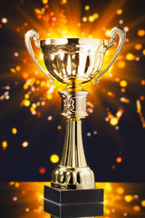 Wall Mural - gold cup trophy against shiny sparks background