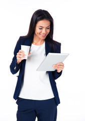 Wall Mural - Cheerful businesswoman holding cup of coffee and tablet computer