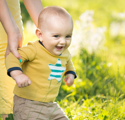 Wall Mural - boy walking on the grass by  parent