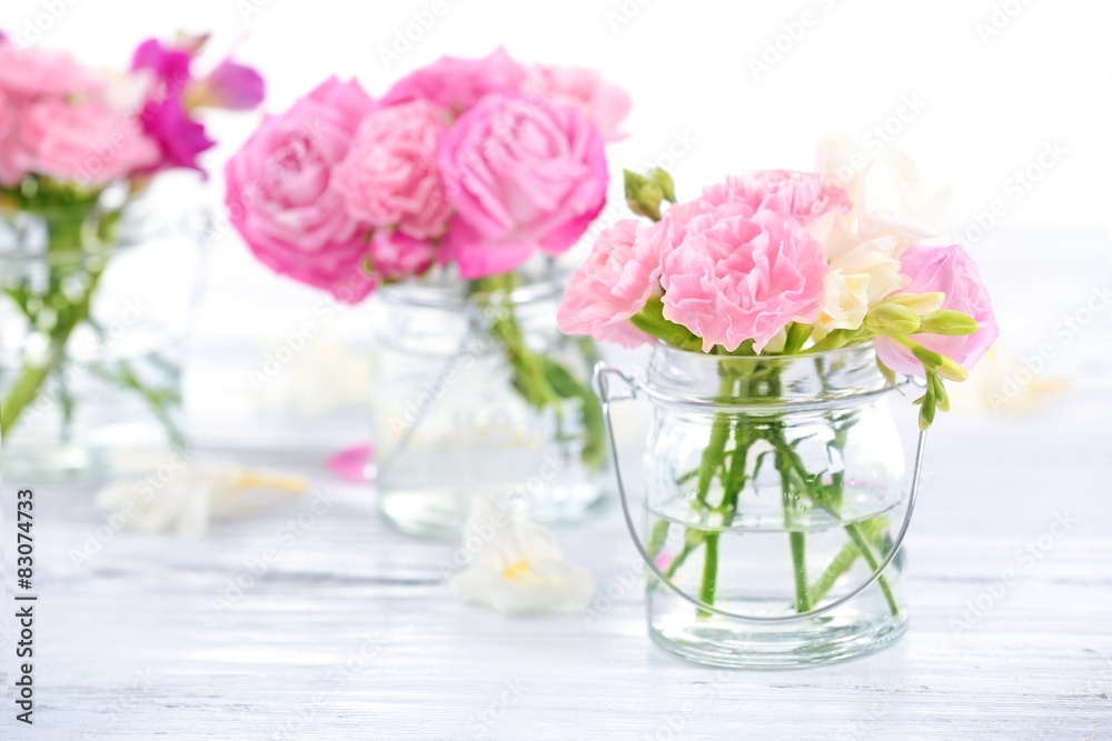 Beautiful spring flowers in glass bottles, closeup