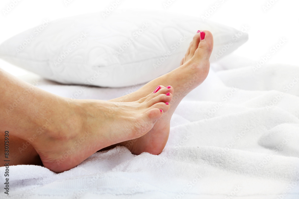 Beautiful female legs on towel, on light background