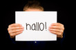 Child holding sign with German word Hallo - Hello in English