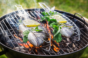 Grilling tasty fish with herbs and lemon