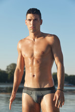 Muscular Man In Swim Briefs Getting Out Of Water