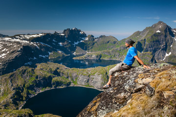 man takes rest on top of mountain in norway